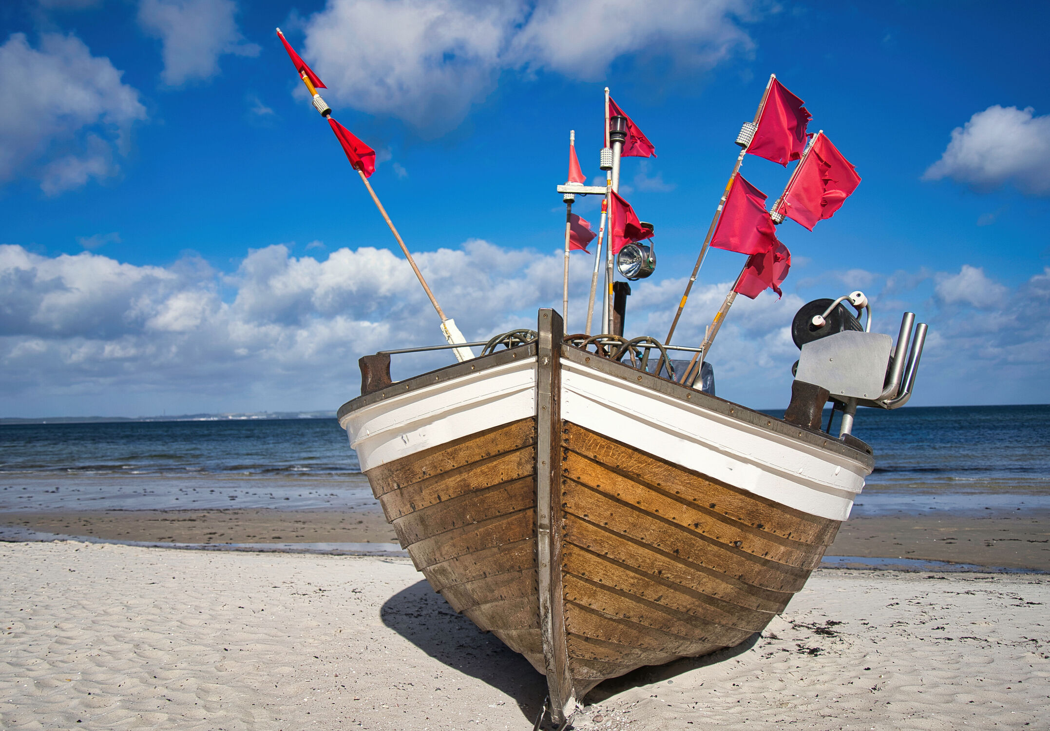 Bild mit Rot, Strand, Sandstrand, Ostsee, Meer, Wolkenhimmel, Insel Rügen, Holzboot, Badeurlaub, fahnen