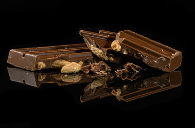 Bild mit Spiegelung, Süßigkeiten, Schokolade, schwarzer Hintergrund, Mandelschokolade