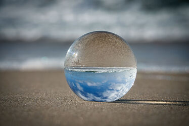 Glass ball on the beach of Baltic Sea. Reflection