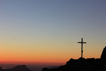 Sunset in the swiss mountains with a summit cross