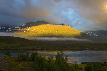 Leuchtender Berg am Fjord bei Tromsö